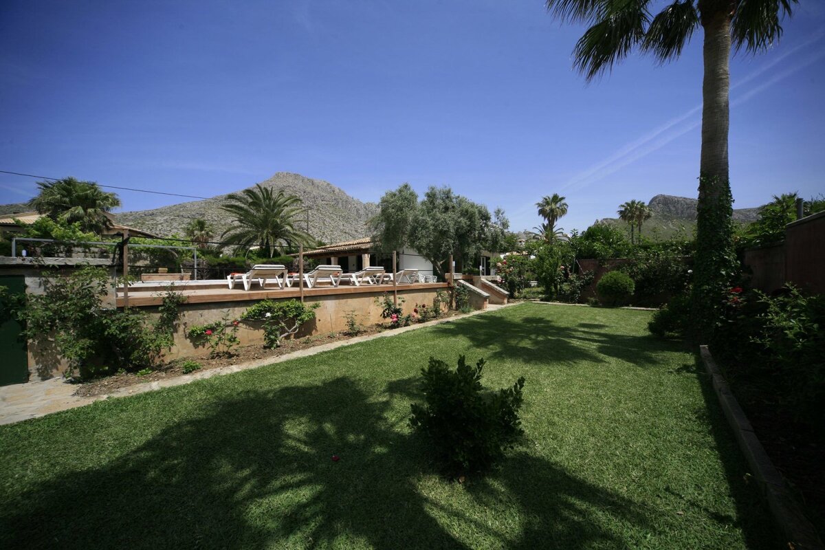 A lush green lawn with a mountain in the background