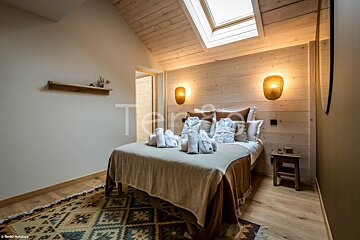 A bedroom with a bed and a rug and the word terra on the wall
