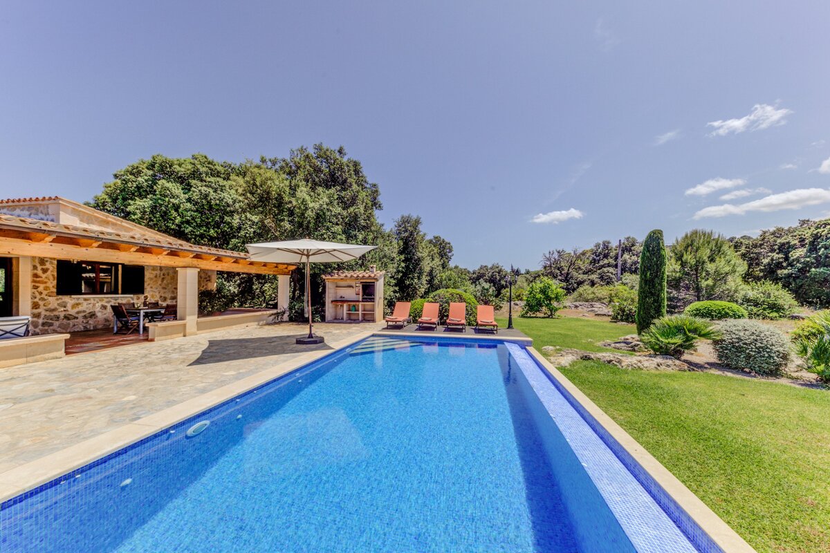 A large swimming pool in front of a house