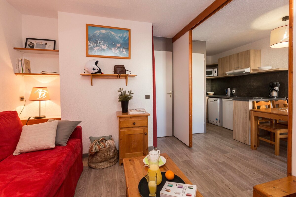 A living room with a red couch and a lamp with the letter b on it