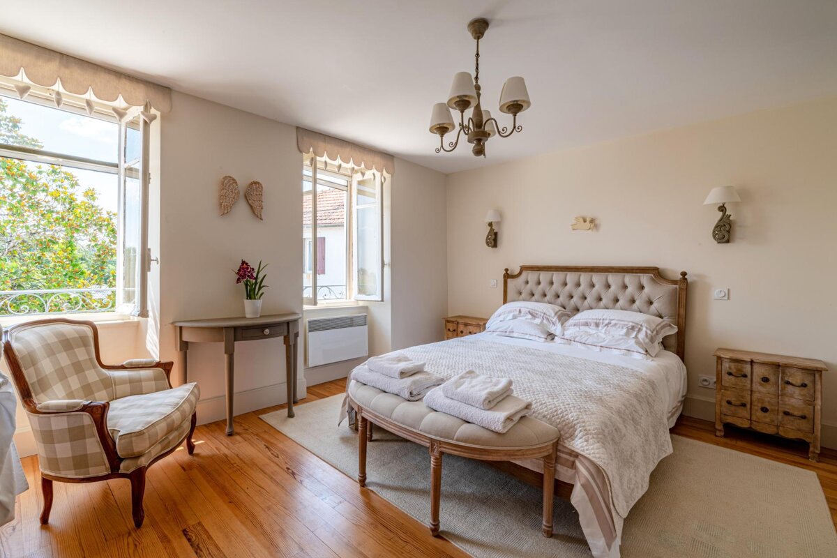 A bedroom with a large bed and a chair