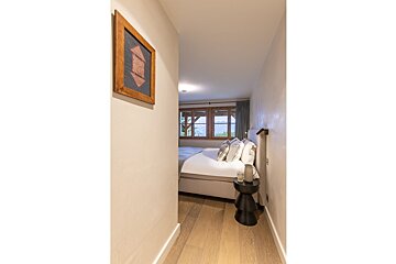A bedroom with a bed and a picture on the wall