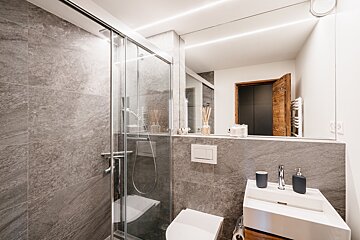 A bathroom with a toilet a sink and a shower