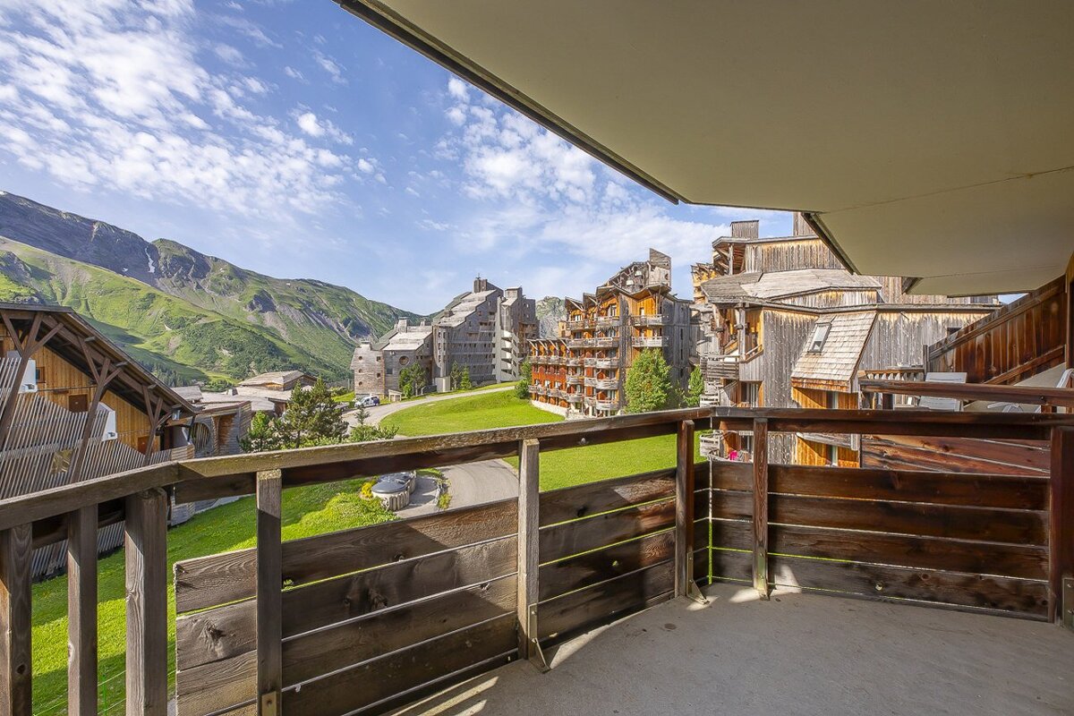 A balcony with a view of mountains and buildings