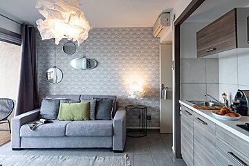 A living room with a couch and a kitchen