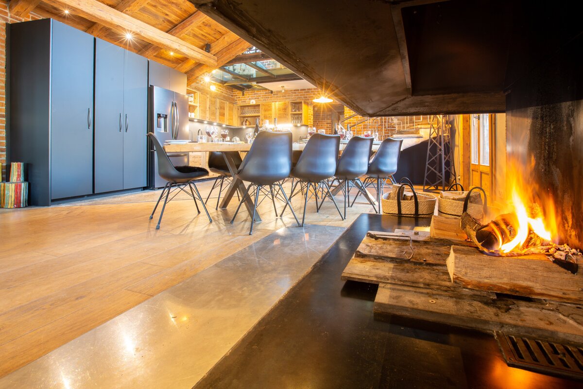 A dining room with a fireplace and a table and chairs
