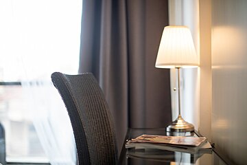 A lamp sits on a desk next to a chair