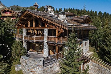 An aerial view of a large stone and wooden house with the word ski on the bottom
