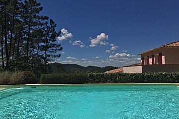 A large swimming pool with a house in the background