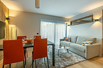A living room with a couch a table and chairs