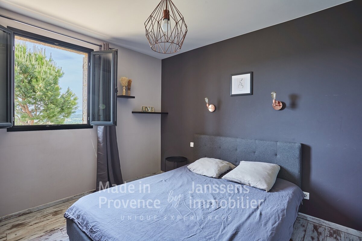 A bedroom with a bed made in provence by janssens immobilier