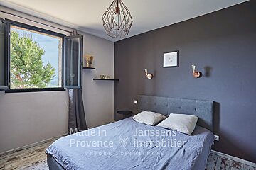 A bedroom with a bed made in provence by janssens immobilier