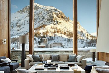 A living room with a view of a snowy mountain