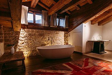 A bathtub in a bathroom with a british flag on the floor
