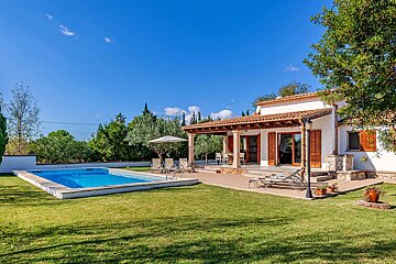 A house with a large swimming pool in front of it