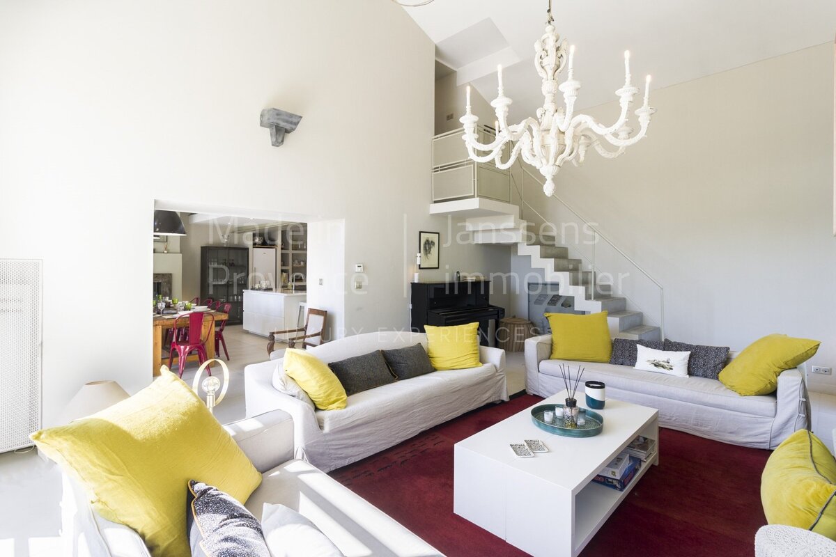 A living room with a white couch and yellow pillows