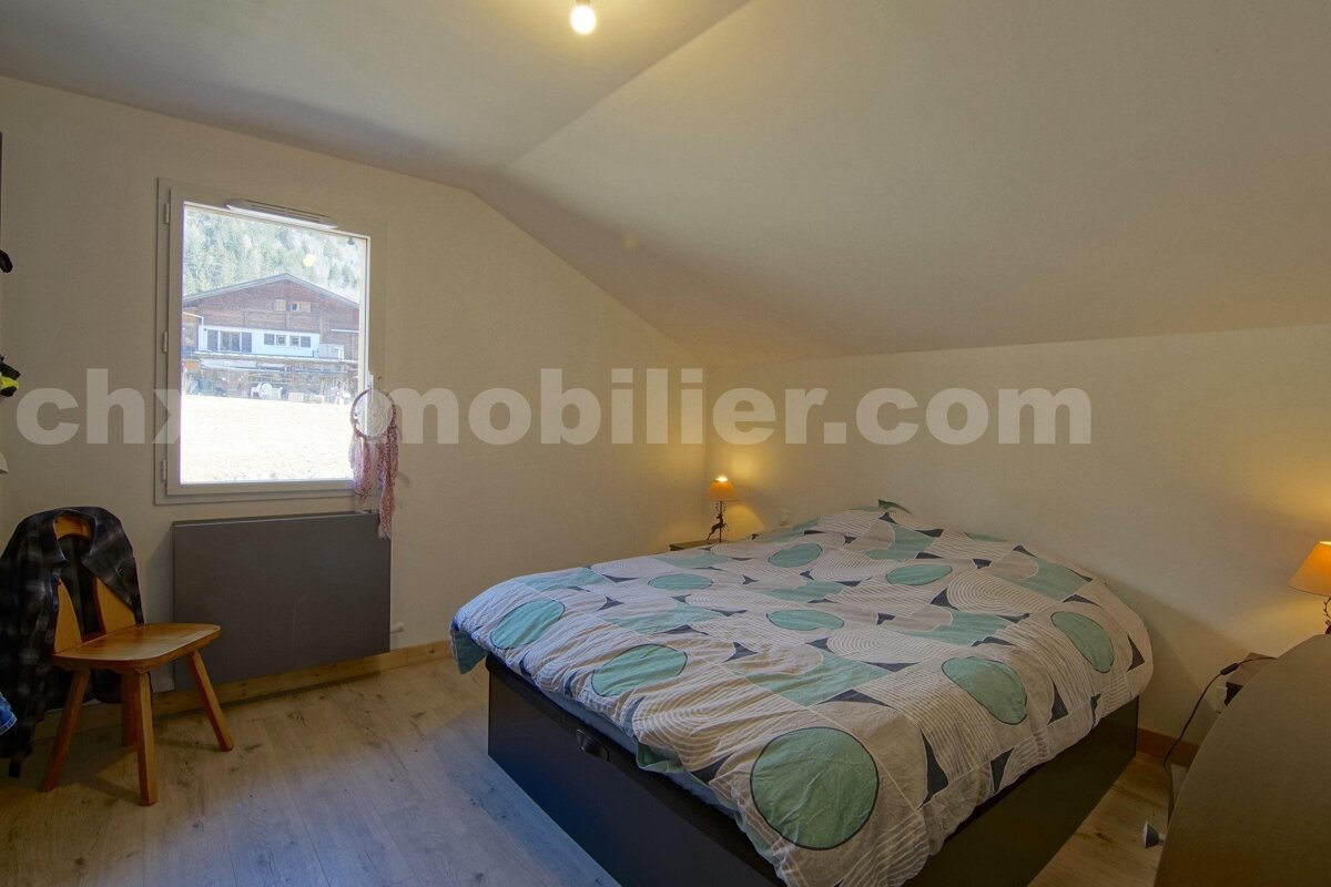 A bedroom with a bed and a window and the website chronomobilier.com