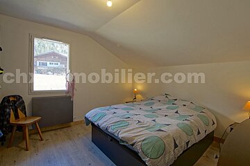 A bedroom with a bed and a window and the website chronomobilier.com