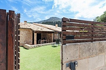 A house is behind a wooden fence with a mountain in the background