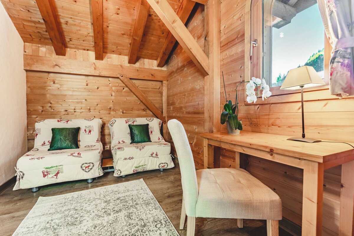 A wooden room with two chairs and a desk