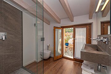 A bathroom with two sinks and a walk in shower
