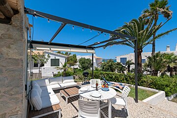 A patio with a table and chairs under a canopy