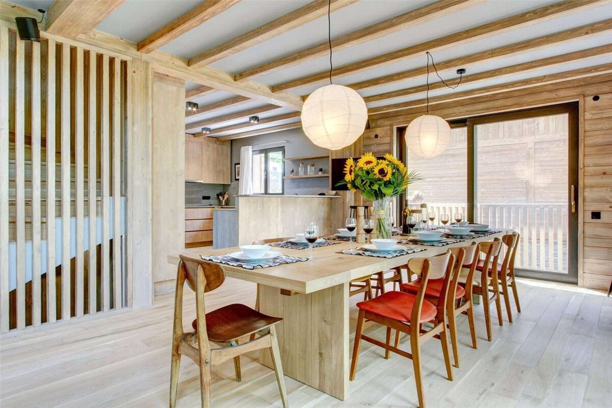 A dining room with a wooden table and chairs