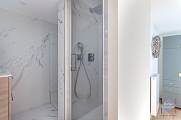 A bathroom with a rental designer logo on the wall