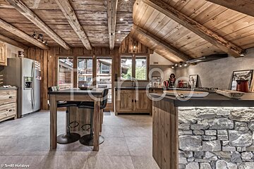 A kitchen with a stainless steel refrigerator and a wooden table