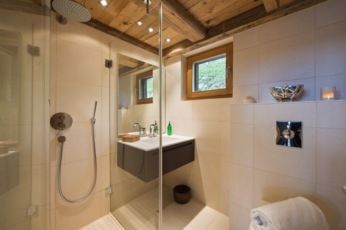 A bathroom with a walk in shower and a sink