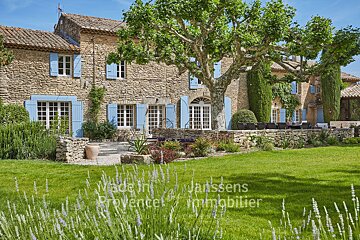 A large stone house with blue shutters is for sale