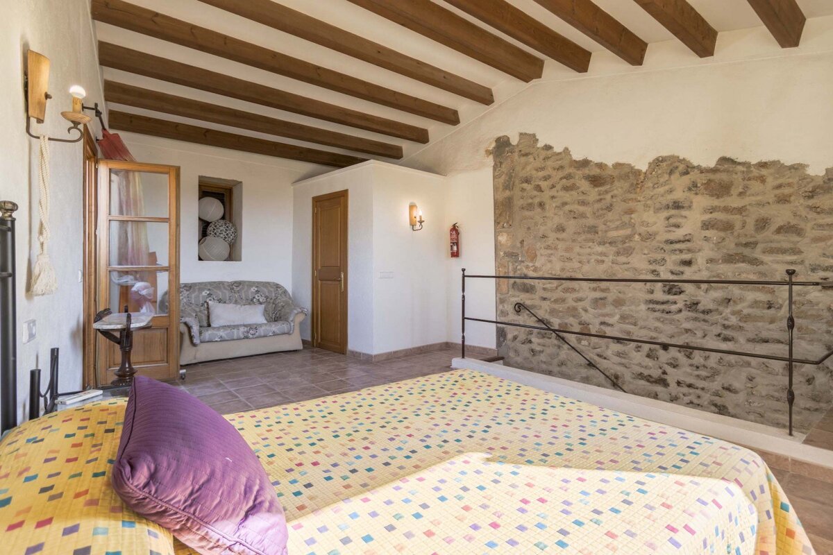 A bedroom with a couch and a fire extinguisher on the wall