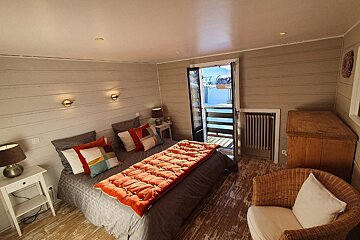 A bedroom with a large bed and a chair