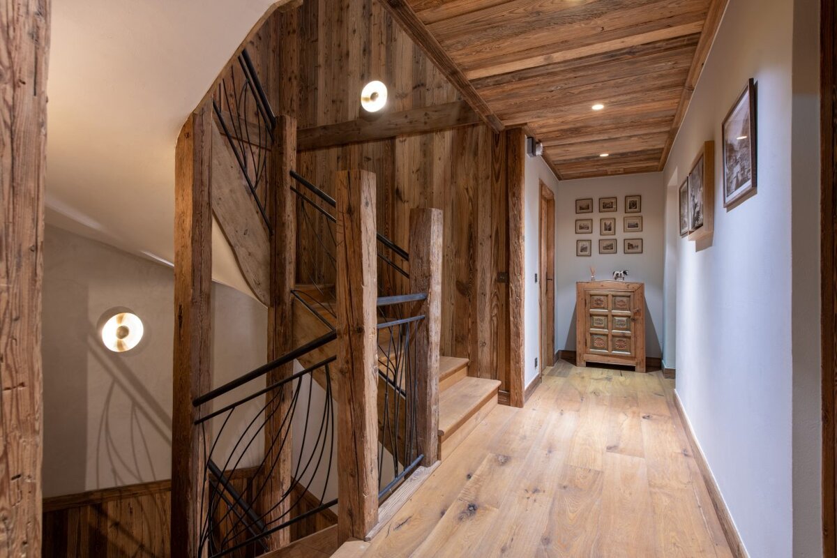A wooden hallway with a staircase and a dresser