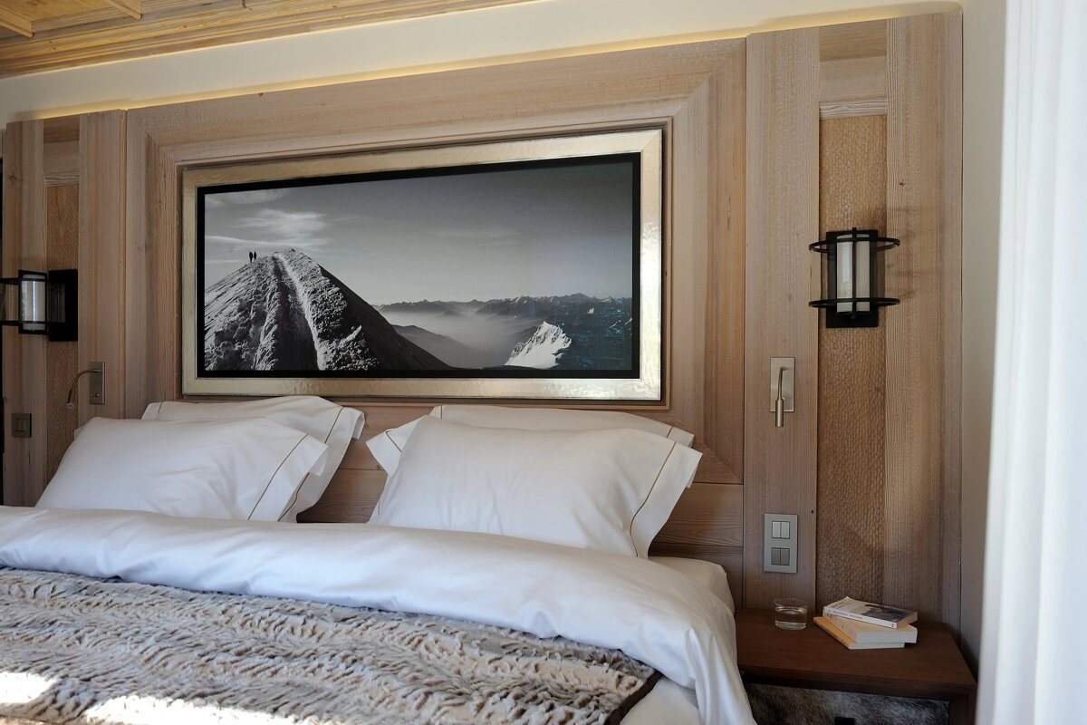 A bed with a picture on the wall above it