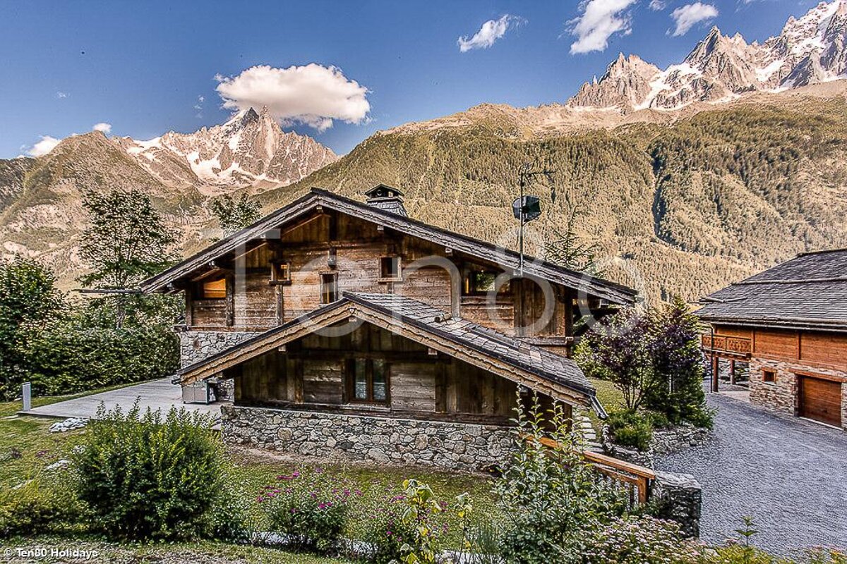 A photo of a chalet with mountains in the background