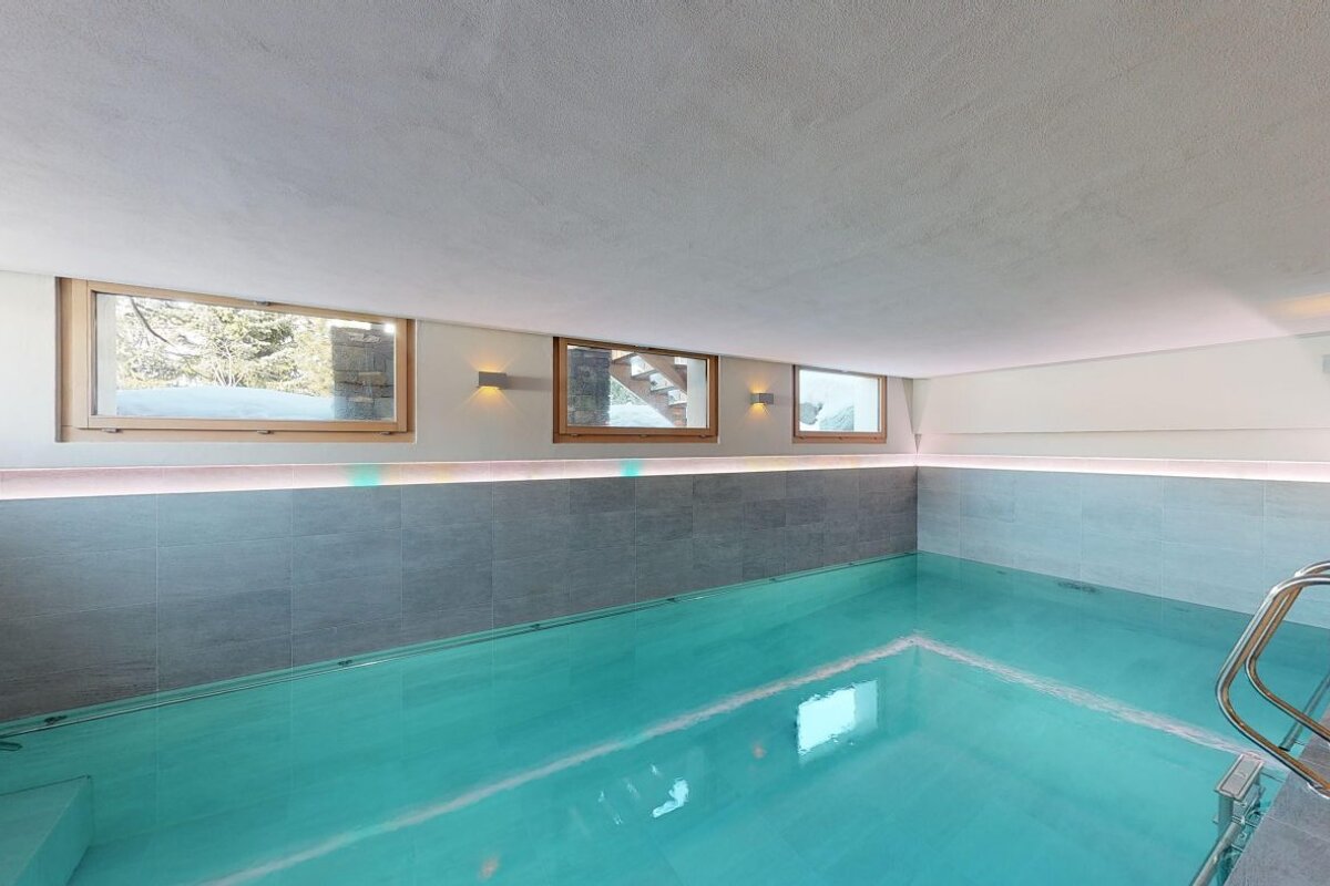A large indoor swimming pool with a staircase leading to it