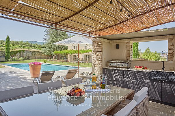 A patio area with a table and chairs that says made in provence immobilier