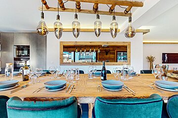 A dining room table with a bottle of wine on it
