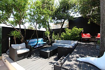 A wooden deck with a couch and chairs on it