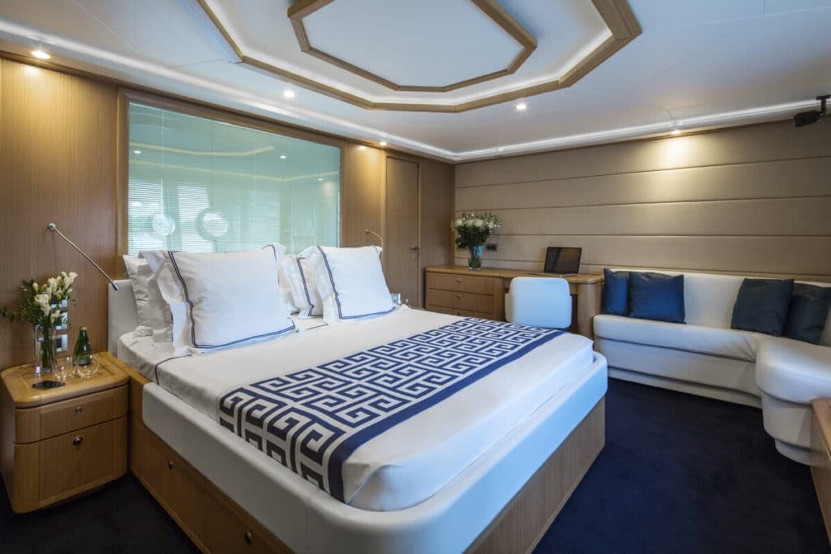 A bed with a blue and white greek key pattern on it