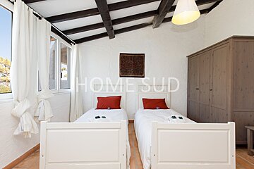 A bedroom with two beds and a sign that says home sud