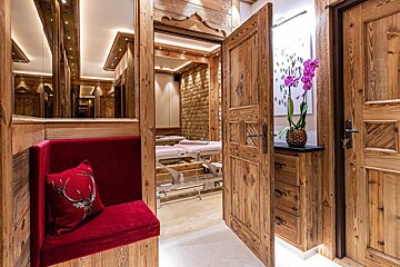 A red pillow with a deer on it sits next to a wooden door