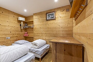 A bedroom with two beds and a picture on the wall