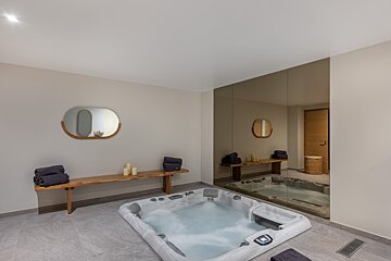 A bathroom with a hot tub and a mirror