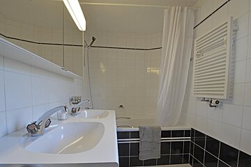 A bathroom with two sinks and a bathtub
