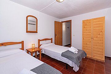 A bedroom with two beds and a mirror on the wall