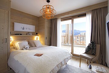 A bedroom with a large bed and a sliding glass door