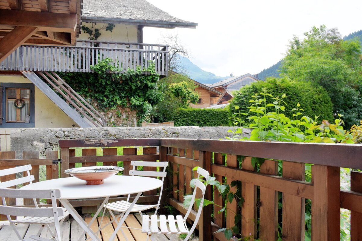 A balcony with a table and chairs and a bowl on it