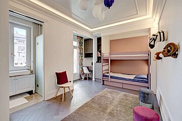 A bedroom with a bunk bed and a chair